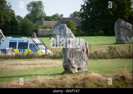 Avebury, Wiltshire, UK. 21. August 2019. Einen Polizeiwagen geht durch das Weltkulturerbe von Avebury, der Heimat der berühmten Henge und alten Steinkreis. Berichte von weit rechts zeremoniellen Aktivität auf Websites wie Avebury und Wayland Smithy, eine neolithische Grabkammer in Oxfordshire, in nationalen Zeitungen vor kurzem veröffentlicht worden. Als Konsequenz, Sicherheit wurde durch den National Trust, die der Jungsteinzeit managt ausgeweitet worden. Quelle: Lee Thomas/Alamy leben Nachrichten Stockfoto