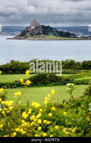 St Michael's Mount tidal Island bei bewölktem Himmel in Mounts Bay aus Feldern mit gelben Bedstraw in Perranuthnoe Cornwall England Stockfoto