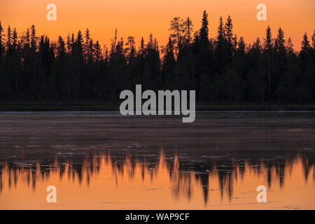 Intensive Sonnenuntergang über dem See in Finnland mit schönen Reflexionen Stockfoto