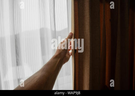 Männer Hand öffnen Vorhang im Schlafzimmer Stockfoto