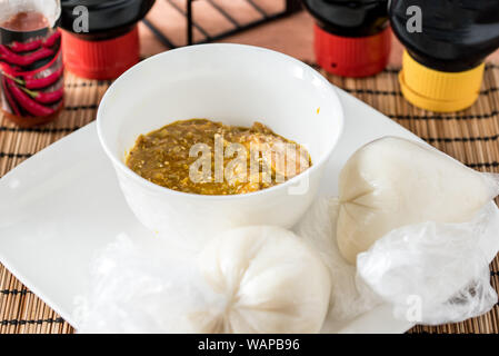 Regionale afrikanische Speisen auf weiße Platte auf hölzernen Hintergrund Stockfoto