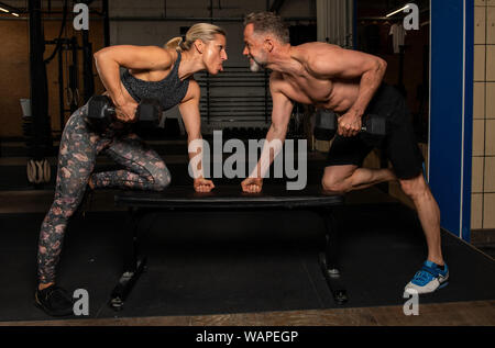 Einen mittleren Alters attraktiv und sportlich Paar zusammen tut ein funktionelles Fitness Training und Spaß haben. Mann und Frau sind das Lachen in der Turnhalle. Stockfoto