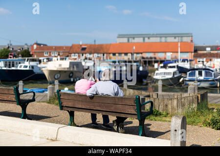 Ein älteres Paar auf einer Bank sitzen bewundern Sie die verschiedenen Boote bis in den Fluss günstig Stockfoto