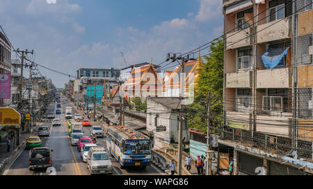 Bangkok, Thailand - 14. Dezember 2017: beschäftigte Straße mit viel Verkehr alte Gebäude und einen Tempel unter einem blauen Himmel Stockfoto