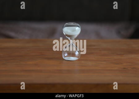 Glas Sanduhr steht auf dem Tisch. Stockfoto