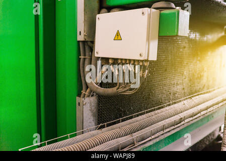 Schaltschrank in einer industriellen Anlage und ein Warnhinweis für Elektrizität. Elektrische Leitungen und Kabel. Hohe Spannung. Stockfoto