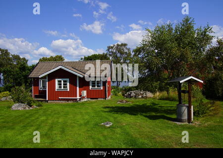 Traditionelle schwedische Ferienhaus auf dem Land gegen einen Teilweise bewölkt blauer Himmel. Stockfoto