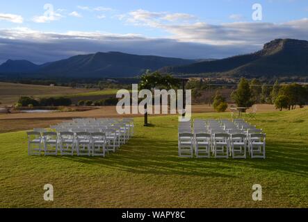 Hochzeit arch und Sitzgelegenheiten bereit für eine Verpflichtung Zeremonie mit Blick auf die Weinberge und Hügel von NSW Hunter Valley Stockfoto