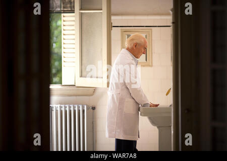 Ein älterer Mann wäscht seine Hände. Stockfoto