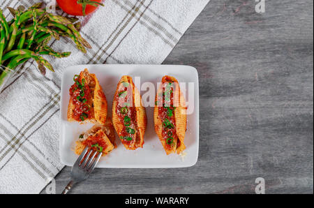 Pasta Muscheln gefüllt mit Ricotta, Parmesan Käse und Spargel. Stockfoto