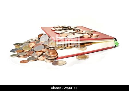 Stapel Münzen fließt aus dem Roten Buch auf weißem Hintergrund, Erfolg der Alphabetisierung und Bildung, Wirtschaft und Finanzen Stockfoto