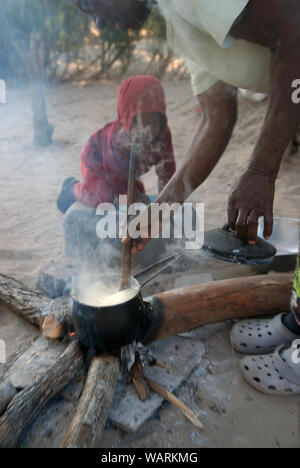 Alte Dame kochen eine Kanne Nshima, einem dicken Brei aus fein gemahlenen Maismehl, Mwandi, Sambia, Afrika. Stockfoto