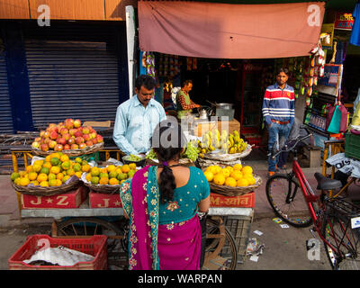 Indische Frau in traditioneller Kleidung Früchte kaufen auf einer Straße bei Champawatt Stadt ausgeht, Kumaon Hügel, Uttarakhand, Indien Stockfoto