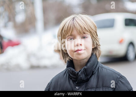 Porträt eines Jungen mit blonden Haaren an einem bewölkten Tag Stockfoto