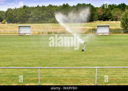 Sprinklerschutz Bewässerung Fußballplatz. System arbeitet auf Frische grüne Gras auf Fußball oder Fußball Stadion Stockfoto
