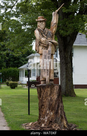 Eine hölzerne Skulptur Werbung Holzschnitzereien ist von einem Baum in der Nähe von Spencerville, Indiana, USA geschnitzt. Stockfoto