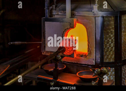 Glasbläser Fertigung, arbeiten auf eine Blase aus geschmolzenem Glas auf eine Stange durch das Heizen von Hand in einem Brennofen an die Werkstatt eines Glas Teekocher Stockfoto