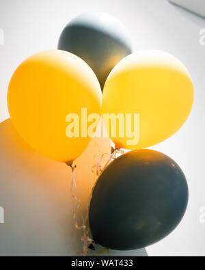Festliche und Feier Konzept mit gelben und grauen Luftballons auf weißem Hintergrund. Stockfoto