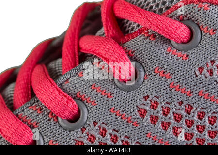 Ein Fragment eines grau Sneaker mit rosa Spitzen hautnah. Sneaker Textur Stockfoto