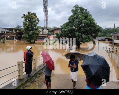 NILAMBUR, Kerala, Indien - August 09, 2019: die Menschen in der Nähe der Überschwemmung versammelt - betroffene Straße in Janathapadi, Nilambur. Stockfoto