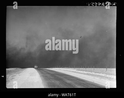 Schwere schwarze Wolken von Staub über die Texas Panhandle, Texas steigend; Englisch: Eine nicht identifizierte Auto auf einer Straße im Texas Panhandle mit schweren Wolken von Staub in den Himmel - ein typisches Phänomen der Dust Bowl. Stockfoto