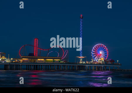 Dämmerung, aus dem angrenzenden Golf von Mexiko Küste getroffen, der Galveston Island Historic Pleasure Pier, ein Vergnügungspark, in Galveston, Texas Stockfoto