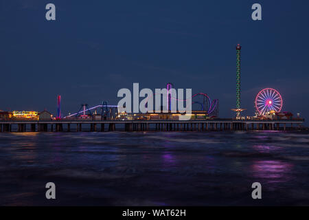 Dämmerung, aus dem angrenzenden Golf von Mexiko Küste getroffen, der Galveston Island Historic Pleasure Pier, ein Vergnügungspark, in Galveston, Texas Stockfoto