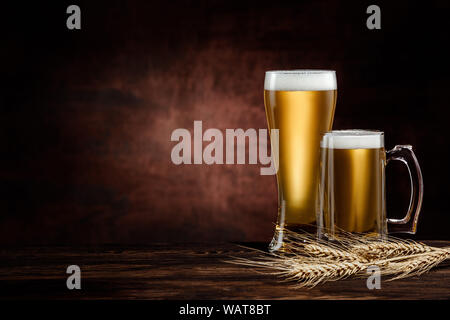 Zwei Gläser kalter golden Bier und Weizen ährchen auf dunklem Hintergrund. Kopieren Sie Platz Stockfoto