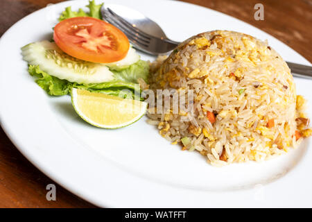 Gebratener Reis mit Schweinefleisch und Gemüse auf Teller, thailändische Küche. Stockfoto