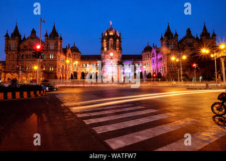 Abenddämmerung an einem beleuchteten Chhatrapati Shivaji Maharaj Terminus (CSMT), der verkehrsreichste Bahnhof in Mumbai, Indien, und ein UNESCO-Weltkulturerbe Stockfoto