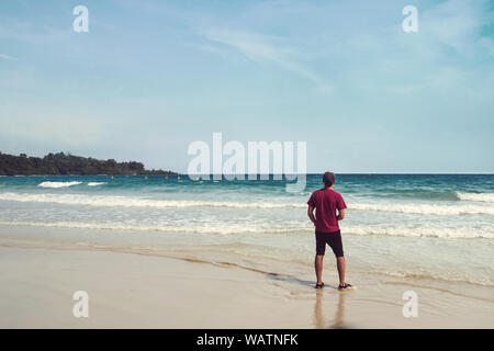 Junger Mann, der am Strand, Sommerurlaub Urlaub und Reisen tropische Insel Konzepte Stockfoto