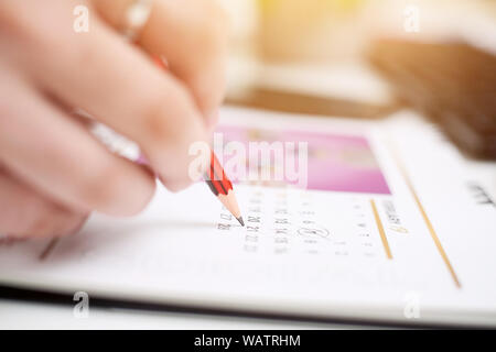 Bild des Menschen schreiben auf Notebook mit Stift und Halten in der Hand mobile. Auf weissem Hintergrund. Stockfoto