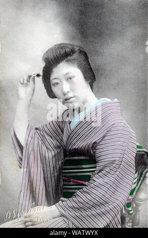 [1910s Japan - Japanische Frau im Kimono] - junge japanische Frau im Kimono und traditionelle Frisur Haar berühren. 20. jahrhundert alte Ansichtskarte. Stockfoto