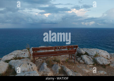 Eine leere Bank für Entspannung auf dem Hintergrund auf das Meer und die Berge. Zypern. Cape Greco National Forest Park Stockfoto