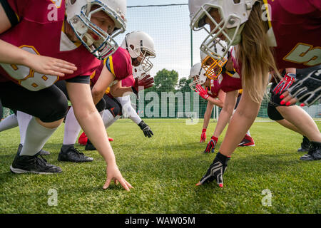 Foto der Athleten, die den Frauen das Tragen von Helmen spielen American Football auf grünem Rasen im Sommer Tag Stockfoto