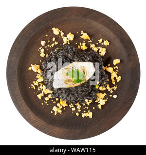 Schwarzes Tintenfisch Risotto mit gebratenen calamar auf runde Holzplatte isoliert auf weißem Stockfoto