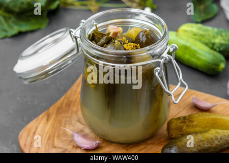 Mixed Pickles - Konserven vergorene Gurken im Glas auf dunklem Hintergrund, horizontale Ausrichtung Stockfoto