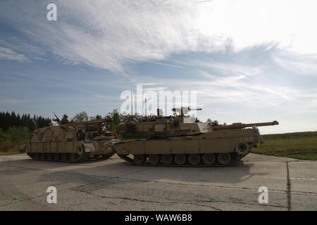 Us-Soldaten in den 1 Geschwader zugewiesen sind, 4.Kavallerie Regiments, 1st Armored Brigade Combat Team, 1.Infanterie Division, wieder ein M1A2 Abrams Tank während einer Live Fire übung Teilnehmenden während der kombinierten Lösung XII am Grafenwöhr Training Area in Deutschland, Aug 6, 2019. Kombinierte Lösung XII ist eine alle zwei Jahre stattfindende Übung, die als Combat Training Center Zertifizierung für Regional zugeteilten Kräfte dient. Diese Wiederholung der Übung erfolgt in zwei Phasen an Grafenwöhr und Hohenfels Training in Bereichen zwischen 12.08.1-11 und 11-27. (U.S. Armee Foto von Sgt. Randis Monroe) Stockfoto