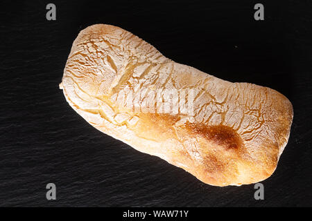 Essen Konzept hausgemachte Artisan im klassischen italienischen Stil Hefeteig Ciabatta Brot auf schwarzem Schiefer mit Kopie Raum Stockfoto