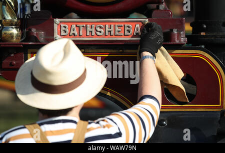 Eine Person poliert die Namen Plakette auf der Robey Showmans Traktor' Batseba' während der Tag einer der Großen Dorset Steam Fair, wo Hunderte von Zeitraum dampfbetriebene Zugmaschinen und schwere mechanische Ausrüstung aus allen Epochen zu präsentieren Großbritanniens reiche industrielle, landwirtschaftliche und Freizeit Geschichte sammeln, bei der jährlichen zeigen, statt über den August Bank Holiday Wochenende von Donnerstag 22. bis Montag, den 26. August. Stockfoto