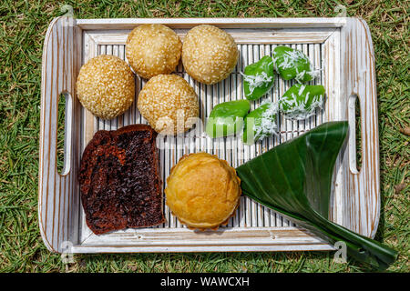 Fach mit traditionellen indonesischen Desserts: Onde - onde, Kue sus Bolu Karamel und klepon. Bali, Indonesien, Stockfoto