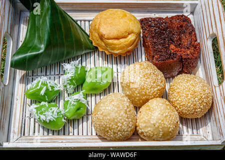 Fach mit traditionellen indonesischen Desserts: Onde - onde, Kue sus Bolu Karamel und klepon. Bali, Indonesien, Stockfoto