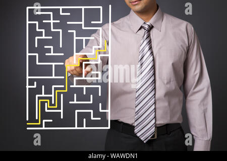 Geschäftsmann berührt Labyrinth auf einem Touchscreen Stockfoto