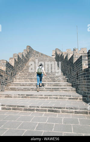 Eine chinesische Frau, die zu Fuss Steintreppe auf der Chinesischen Mauer am huanghua Cheng Scenic Area Beijing China. Stockfoto