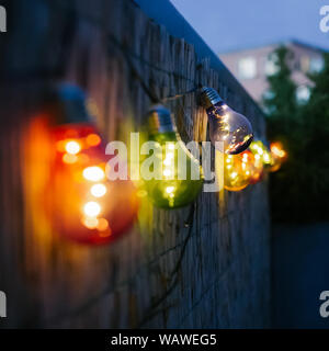 Bunte Glühbirnen auf einem städtischen Terrasse oder einen Balkon in der Nacht. Eventing, Garten und Dekoration. Stockfoto
