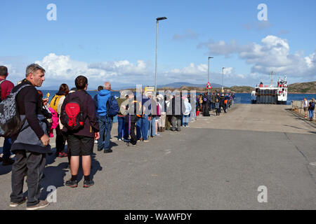 Lange Warteschlangen von Menschen, vor allem Touristen, die warteten, Iona Fionnphort Calmac Fähre in der Inneren Hebriden von Schottland Stockfoto