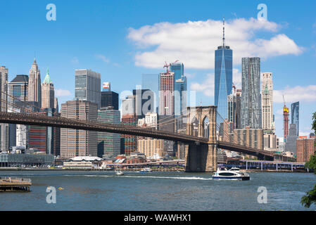 Lower Manhattan, Aussicht im Sommer des Financial District Gebäude in Lower Manhattan mit der Brooklyn Brücke im Vordergrund, New York City, USA Stockfoto