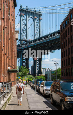 Dumbo Brooklyn, Rückansicht einer reifen Frau nähert sich die Manhattan Bridge in Washington Street in Dumbo, Brooklyn, New York City, USA. Stockfoto