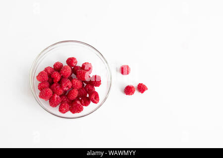 In der Nähe von Reifen frisch gepflückte Himbeeren in eine Glasschüssel auf einem weißen Tisch Beeren im Garten Stockfoto