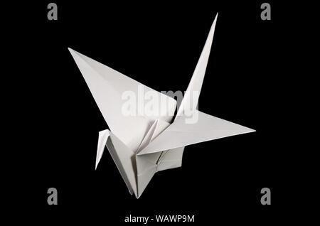 Weiß origami Crane, tsuru, auf schwarzem Hintergrund. Japanische Kunst des Papierfaltens. Flache quadratische Blatt Papier in fertige Skulptur übertragen. Stockfoto